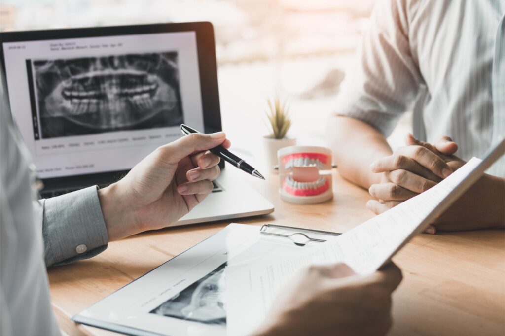 A dentist explaining dental implant treatment to a patient - Newlife Dental Practice