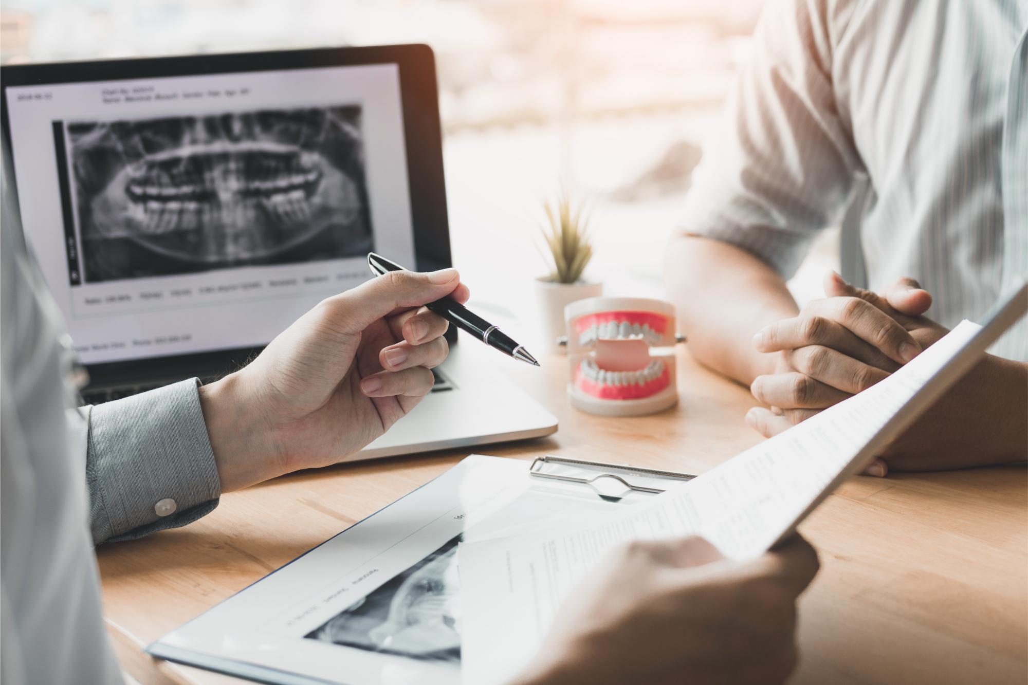 A dentist explaining dental implant treatment to a patient - Newlife Dental Practice
